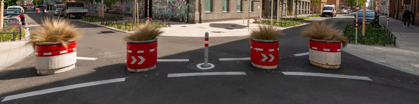 Titelbild des Projektes: Bild eines "Diagonalfilters" des Supergrätzls, bestehend aus bepflanzten, alten Mülltonnen der Donauinsel. 